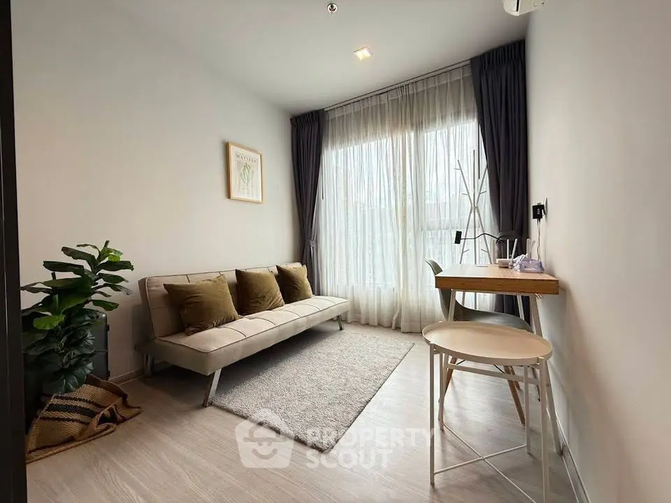 Modern living room with cozy sofa, stylish decor, and natural light from large window.