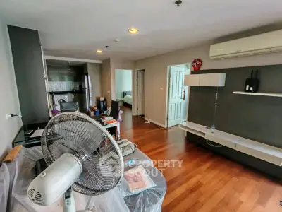 Spacious living room with modern decor and open kitchen layout in a stylish apartment.