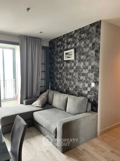 Modern living room with stylish gray sofa and geometric accent wall