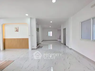 Spacious modern living area with sleek marble flooring and ample natural light.