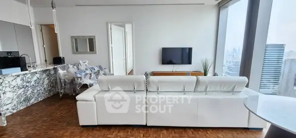 Luxurious modern living room with panoramic city view and elegant marble kitchen.