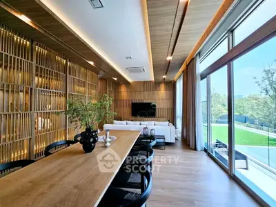Luxurious living room with wooden accents and large windows overlooking greenery.