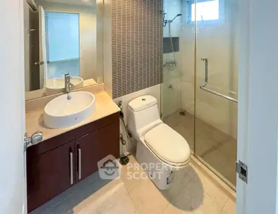 Modern bathroom with glass shower and stylish vanity in a contemporary home.