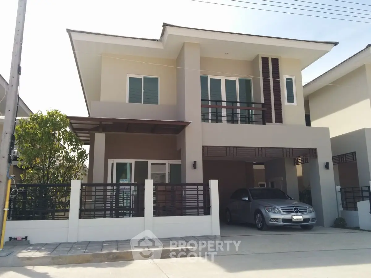 Modern two-story house with sleek design and spacious driveway in a suburban neighborhood.