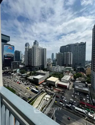 Stunning cityscape view from a high-rise balcony overlooking bustling urban streets and modern skyscrapers.