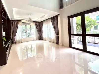 Spacious living room with elegant curtains and large windows offering natural light.