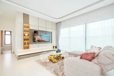 Luxurious living room with modern decor, large TV, and elegant furniture in a bright, airy space.