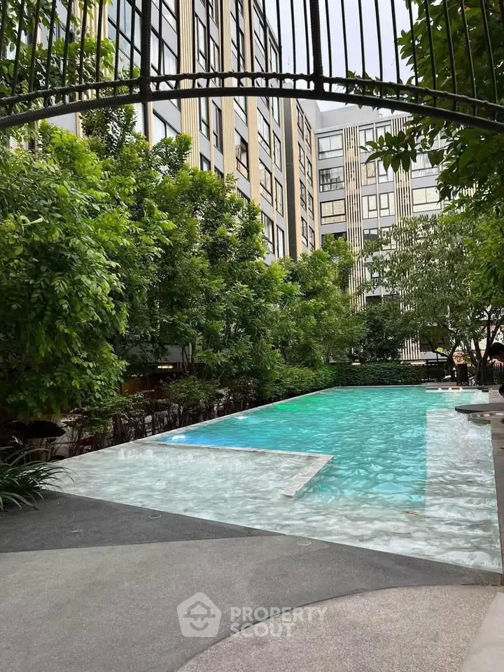 Luxurious apartment complex with serene pool and lush greenery