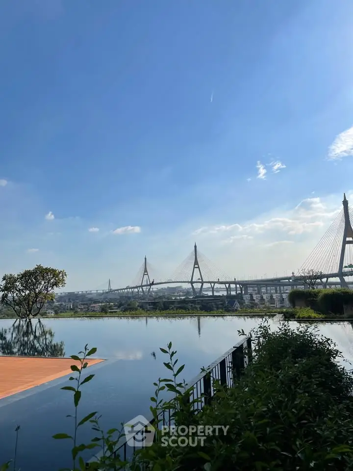 Stunning infinity pool with panoramic cityscape and bridge view under a clear blue sky.