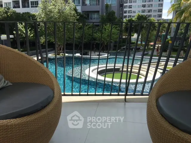 Luxurious balcony view overlooking a stunning modern pool in a high-end residential complex.