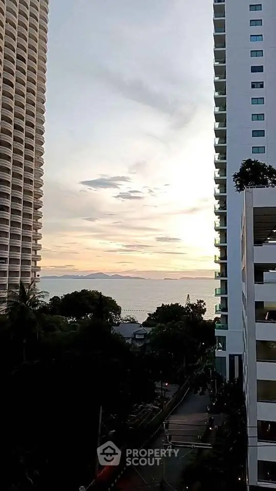 Stunning ocean view between modern high-rise buildings at sunset, perfect for urban living.