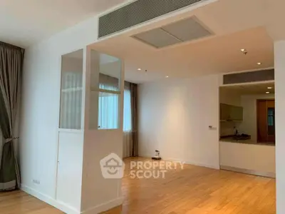 Spacious modern living area with hardwood floors and open kitchen layout