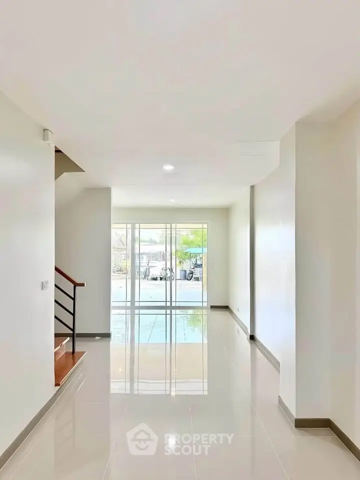 Spacious modern interior with glossy floors and large windows offering ample natural light.