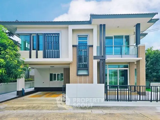 Modern two-story house with sleek design and large windows in a serene neighborhood.