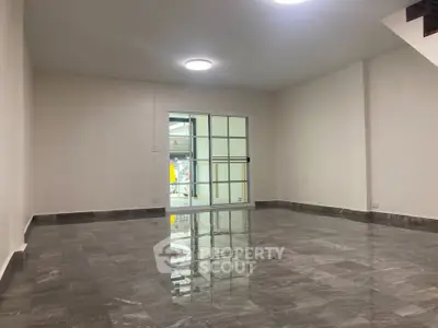 Spacious modern living room with glossy marble flooring and large window.