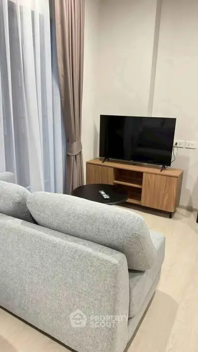 Modern living room with cozy gray sofa and sleek TV setup