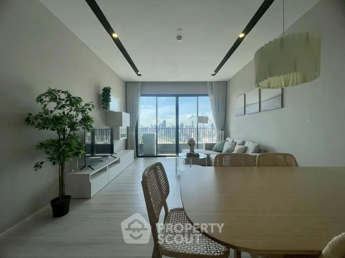 Spacious modern living room with city view, stylish furniture, and large windows for natural light.
