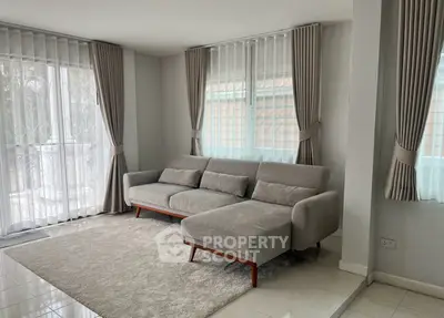 Spacious living room with modern gray sofa and elegant curtains, perfect for relaxation and entertaining.