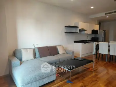 Modern living room with sleek kitchen and cozy sectional sofa.