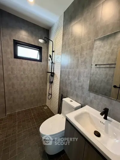 Modern bathroom with sleek design, featuring a walk-in shower and contemporary fixtures.