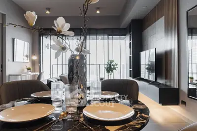 Modern living room with elegant dining setup and large windows offering natural light.