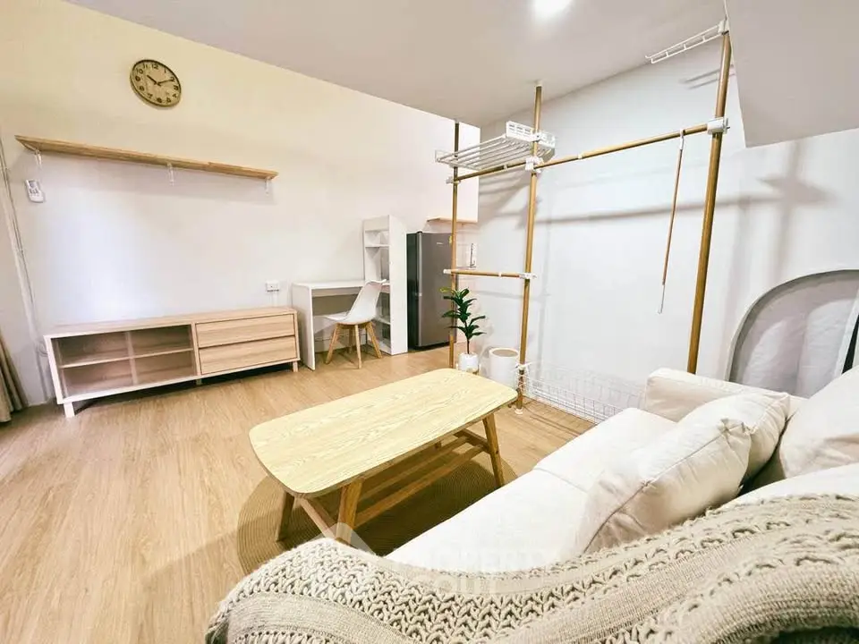 Modern living room with cozy sofa, wooden coffee table, and minimalist decor in a bright apartment.