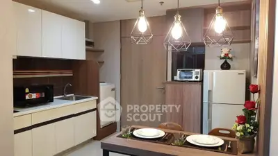 Modern kitchen with dining area, featuring stylish lighting and contemporary appliances.