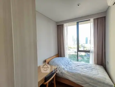 Cozy bedroom with city view, featuring a single bed and study desk, perfect for urban living.