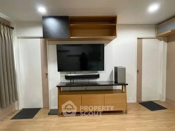 Modern living room with sleek TV setup and wooden cabinetry