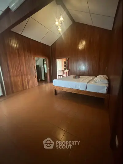 Spacious wooden bedroom with high ceiling and cozy lighting