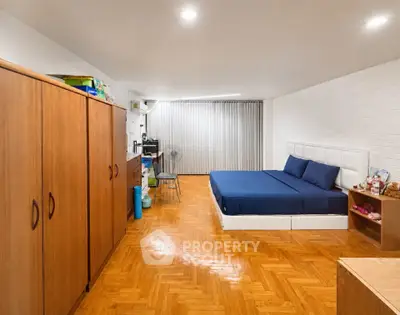Spacious bedroom with wooden flooring and modern furnishings, ideal for comfort and relaxation.