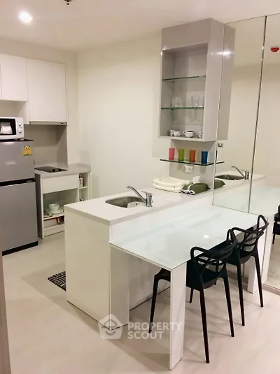 Modern kitchen with sleek design, featuring a compact layout and stylish dining area.