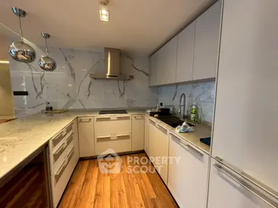 Modern kitchen with sleek cabinets and marble backsplash in a stylish home.
