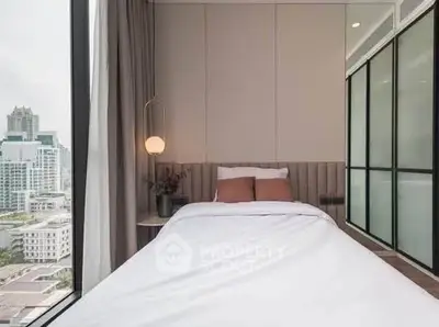 Modern bedroom with floor-to-ceiling windows offering stunning city views, featuring sleek design and cozy ambiance.
