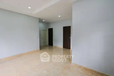 Spacious empty room with tiled flooring and neutral walls, perfect for customization.