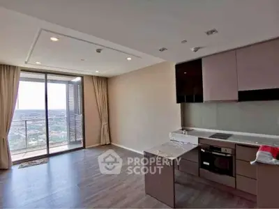 Modern kitchen with open layout and balcony view in high-rise apartment.