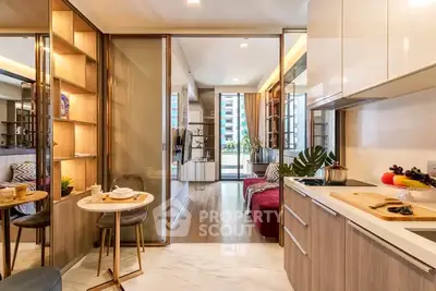 Modern open-layout kitchen and living room with stylish decor and natural light.