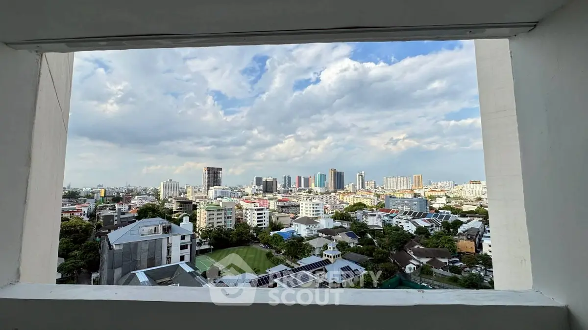 Stunning cityscape view from a high-rise window showcasing urban skyline and blue sky.