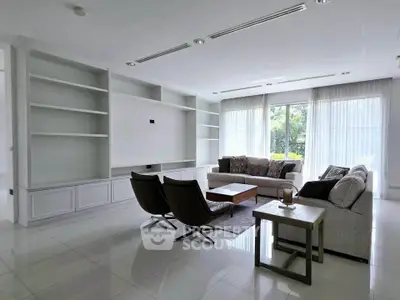 Spacious modern living room with elegant furniture and large windows offering natural light.