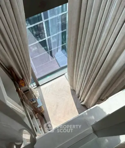 Elegant modern interior with floor-to-ceiling windows and luxurious curtains, showcasing a stylish and bright ambiance.