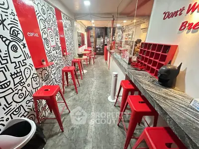 Trendy cafe interior with red stools and artistic wall decor