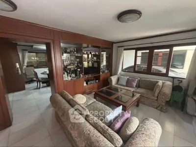Spacious living room with elegant wooden cabinetry and cozy seating area, perfect for family gatherings.