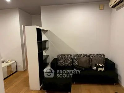 Modern living room with stylish black sofa and wooden flooring