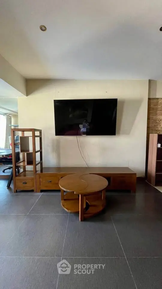 Spacious living room with modern TV setup and stylish wooden furniture