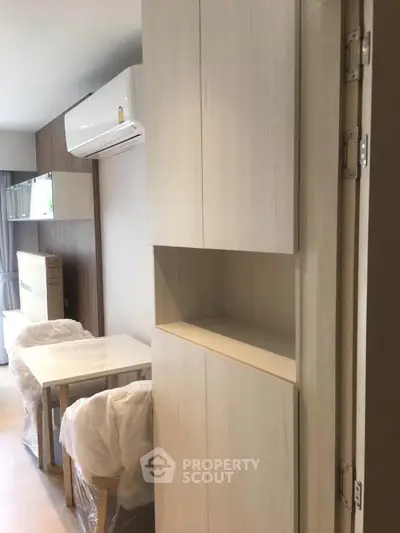 Modern apartment interior with dining area and air conditioning unit.