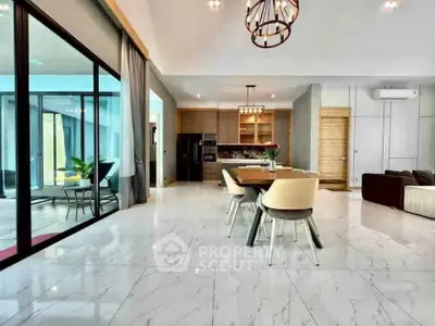 Spacious modern living room with open kitchen and elegant dining area, featuring marble flooring and stylish lighting.