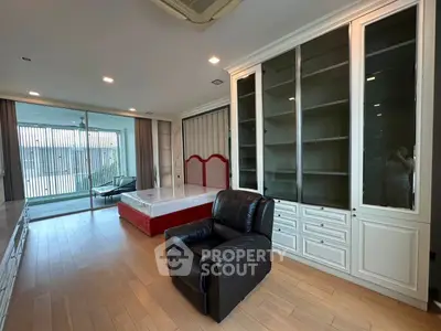 Spacious living room with modern furniture and large glass doors leading to a balcony.
