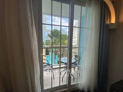 Charming balcony view with poolside scenery and cozy seating area, perfect for relaxation.
