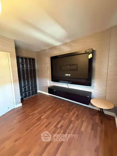 Spacious living room with modern TV mount and wooden flooring