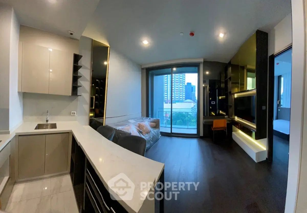 Modern apartment interior with open kitchen and city view balcony, featuring sleek design and ample natural light.